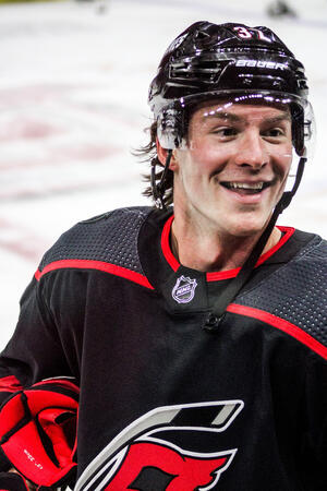 Canes forward Andrei Svechnikob (#37) smiling at fans on the bench during warmups.